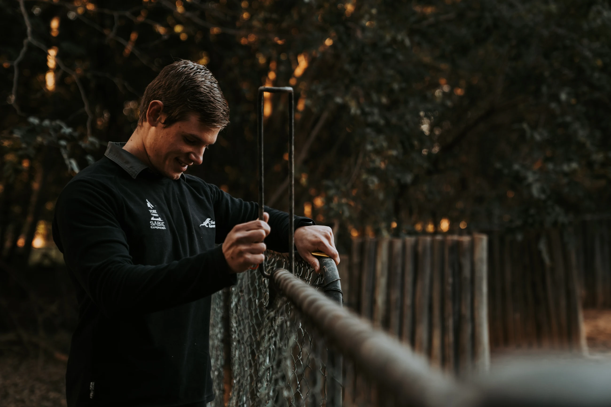 A person beside a fenced outdoor enclosure