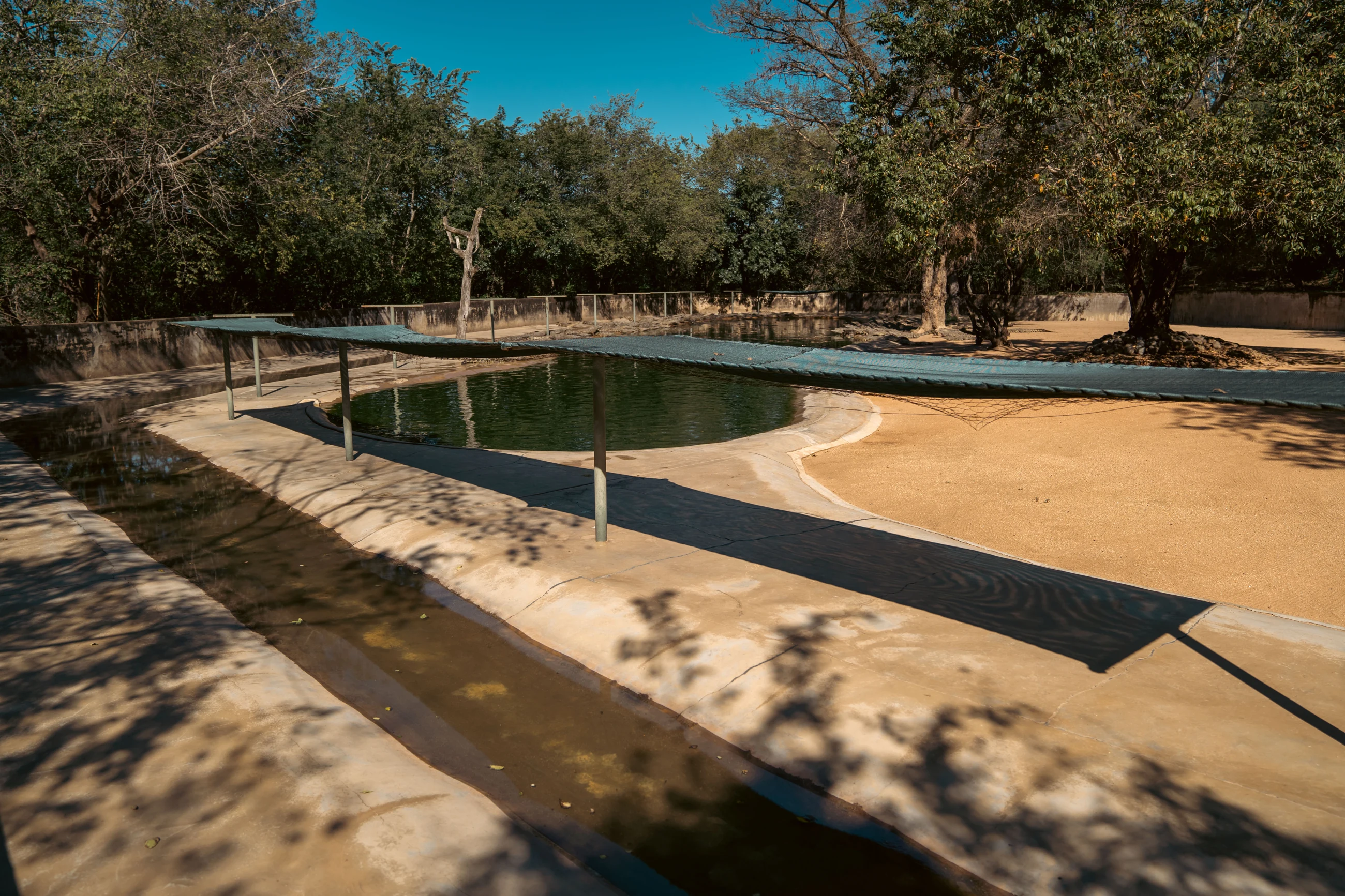 Water and a shaded structure in an outdoor enclosure